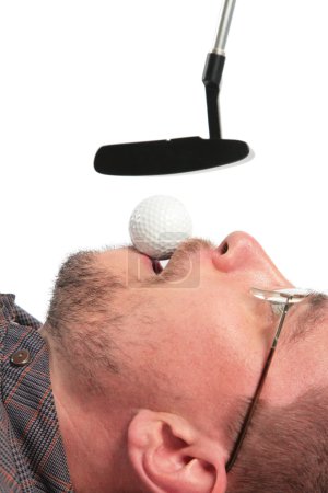 Lying man holds in mouth ball for golf