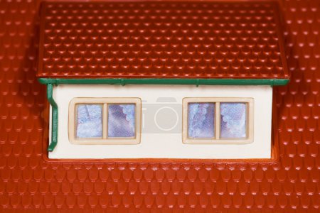 Attic on roof of toy plastic house,two windows