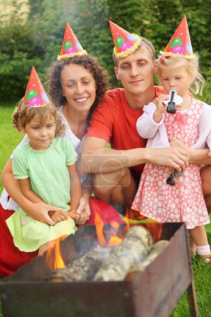Happy family with children near brazier on picnic, happy birthda