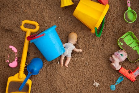 The thrown toys in a sandbox