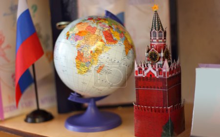 Russia flag, globe and Kremlin tower on shelf