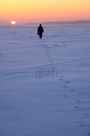 Man goes through the snowy field