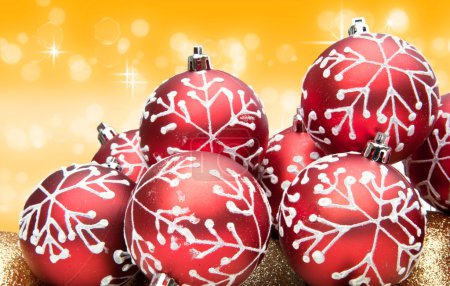 Red Christmas bauble decorations on warm golden background