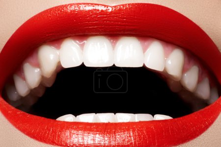 Close-up happy female smile with healthy white teeth, bright red gloss lips