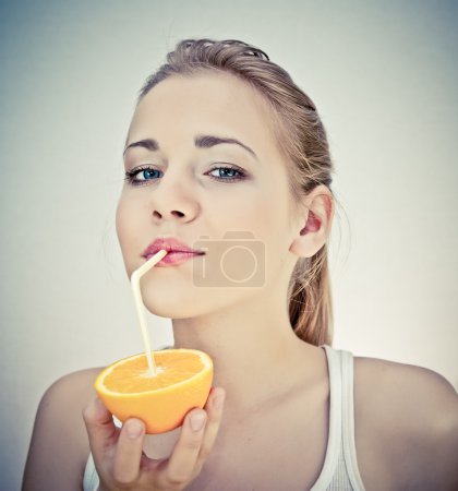 Beautiful girl drinks natural orange juice