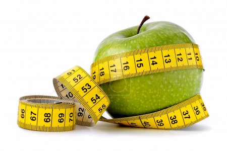 Green apple with measuring tape