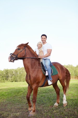 Little girl with father on a horse