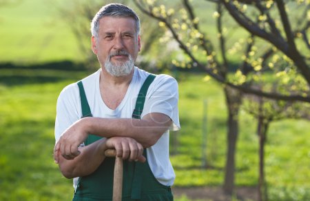 Portrait of a senior man gardening in his garden