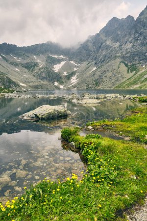 Hincovo pleso. Pure lake with a rocky bottom on the background of the mountains of the High Tatras