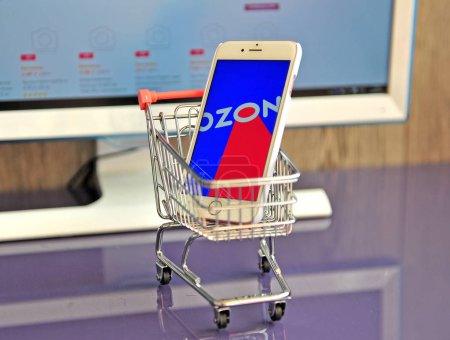 Smartphone with Ozon logo in shopping cart