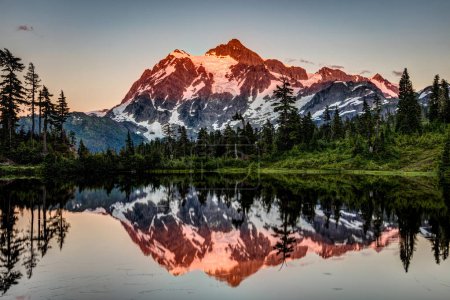 Last glow on the peak of mount Shuksan reflected in the very calm Picture Lake while on a day adventure, hiking at Mount Baker area in the state of Washington, Pacific Northwest, USA