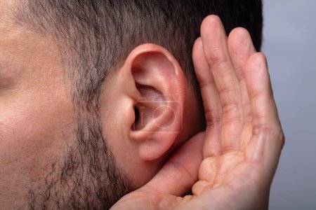 Close-up Of A Man Trying To Hear With Hand Over Ear