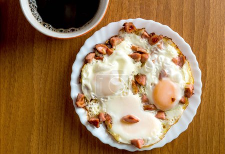 Fried eggs with sausage and black coffee