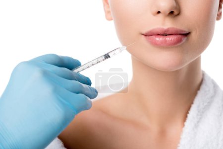 partial view of doctor in latex glove giving lip injection with syringe to woman isolated on white