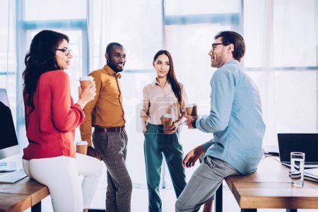 interracial business colleagues having conversation during coffee break in office