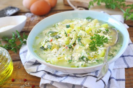Italian stracciatella zucchini soup: parsley, eggs and cheese