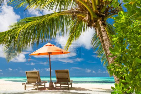 Perfect tropical beach. Idyllic paradise beach landscape for background or wallpaper. Design of summer vacation holiday concept. Chairs under palm leaves with amazing sea view