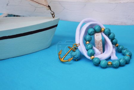 turquoise gemstone jewelry - nautical jewelry with gold anchor - turquoise background