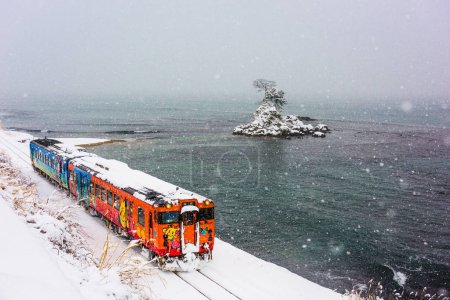 Amaharashi Coast Quasi-national Park, Japan - JANUARY 23, 2017: A Himi Line Train passes the Amaharashi Coast during winter.