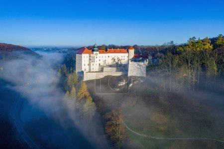Historic castle Pieskowa Skala near Krakow in Poland. Aerial view in fall at sunrise in morning fog.