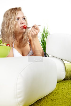 Blonde woman eating salad