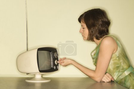 Woman dialing television.