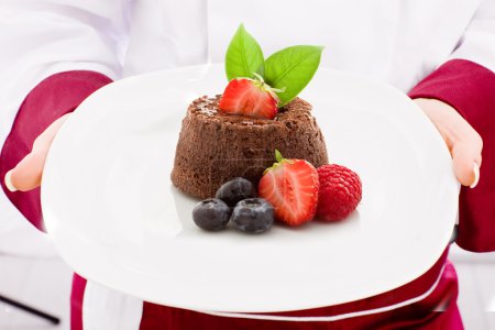 Chef presenting Chocolate cake with strawberries