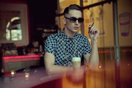 Handsome young man sitting in coffee bar