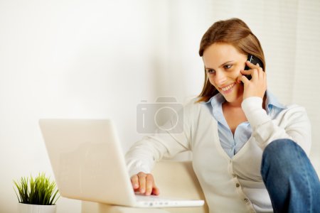 Woman working on laptop and on the phone
