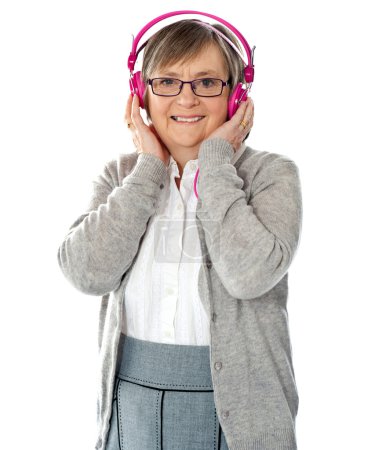 Attractive old lady wearing headphones