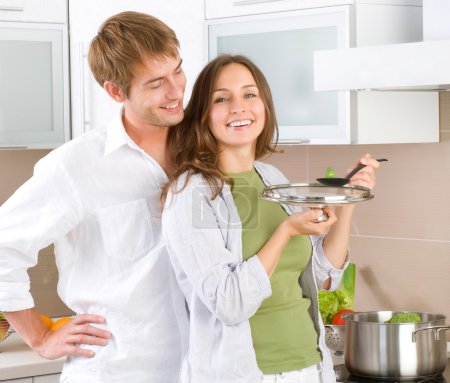 Young happy couple cooking together at home kitchen