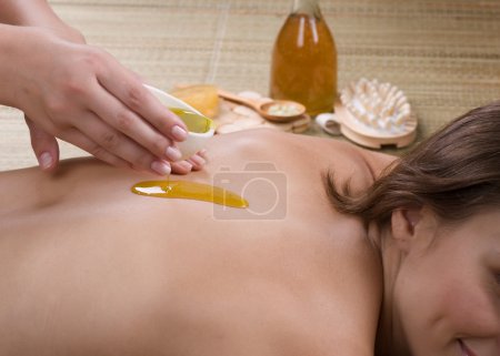 Spa. Young Woman Getting A Massage. Pouring Massage Oil