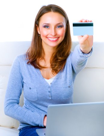 Smiling Woman shopping online with credit card and computer.Inte