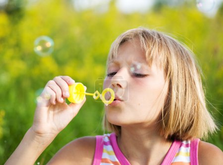Little Girl Blowing Soap Bubbles