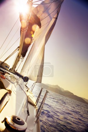 Yacht Sailing against sunset.Sailboat