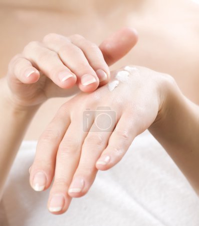 Female applying moisturizer to her Hands after bath.