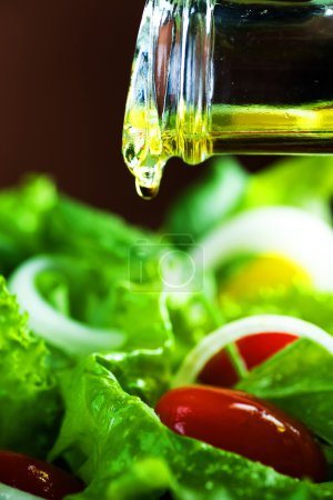 Healthy Salad And Pouring Olive Oil Closeup