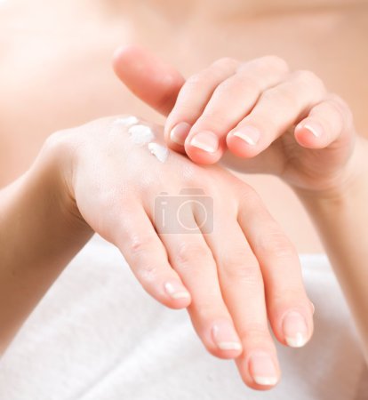 Female applying moisturizer to her Hands after bath
