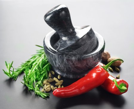 Mortar With Pestle And Herbs. Over Black Background