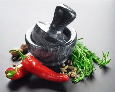 Mortar With Pestle And Herbs. Over Black Background
