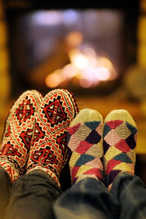 Young romantic couple relax on sofa in front of fireplace at hom