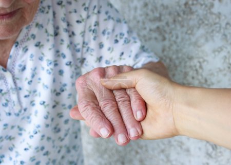 Caregiver holding seniors hand