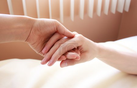 Holding hand of a sick loved one