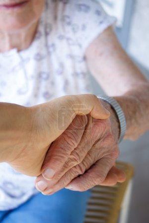 Caregiver holding seniors hand
