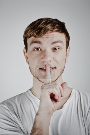 Young man with his finger over his mouth