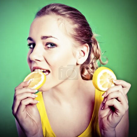 Portrait of beautiful woman, she eating fresh lemon