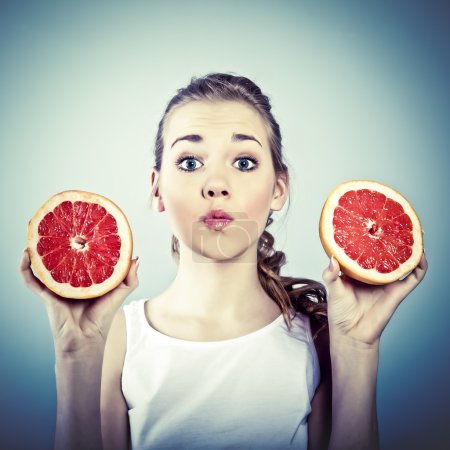 Portrait of young crazy woman with grapefruit