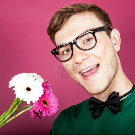 Young smiling man holding a bouquet of flowers