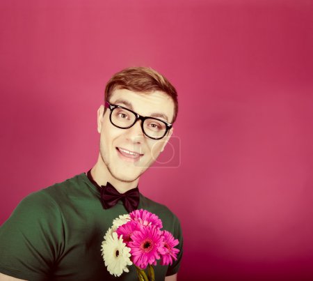 Young smiling man holding a bouquet of flowers