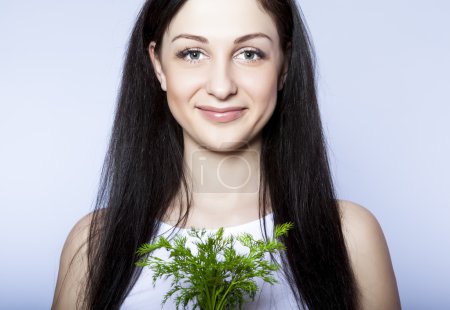Portrait beautiful young woman smiling holding green dill